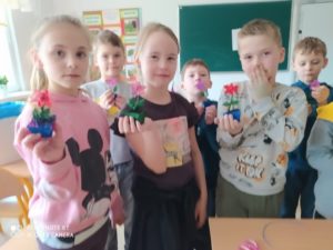 Dzieci prezentujące stworzone kwiatki